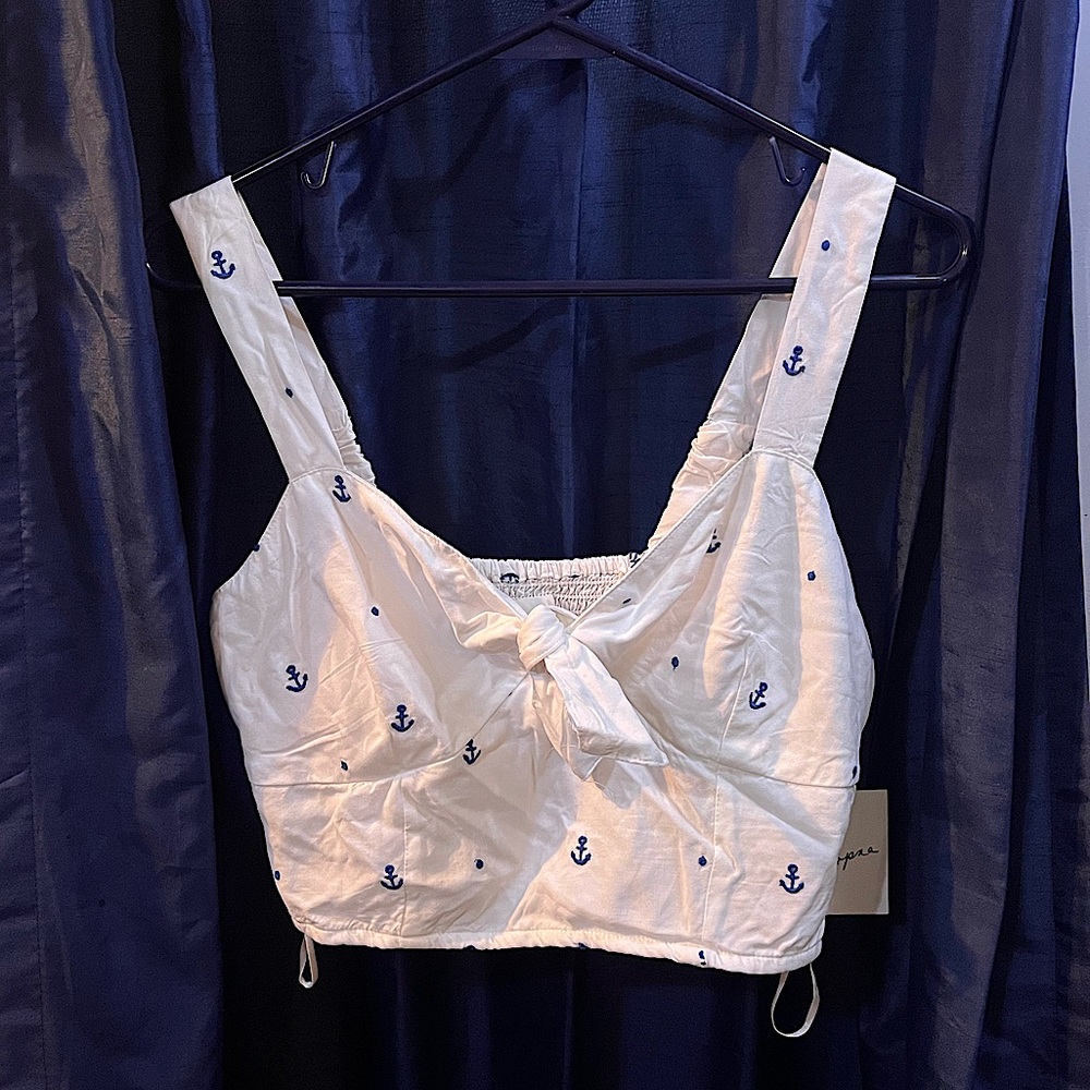 White crop top with navy blue anchor pattern. Fitted bust. Tie front.